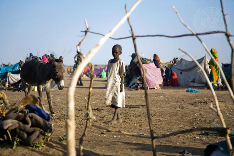 A child and donkey stand in a temporary camp near Shangil Tobaya, North Darfur.